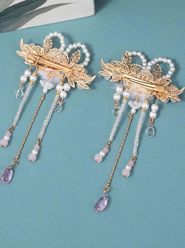 Pair of lolita hair clips back view flat lay, showing alligator clip mechanism and matching design, teal background, top-down perspective