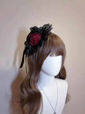 Black lace Lolita headpiece with burgundy flower accent displayed in front three-quarter perspective on model with brown wavy hair