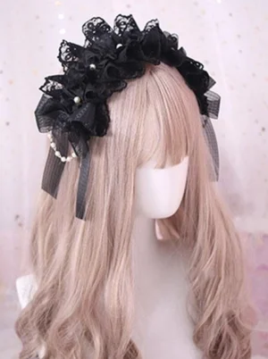 Lolita headdress three-quarter side view displaying black lace ruffles faux pearl chain and long black ribbon straps on mannequin