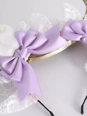Close-up overhead side view of lolita headdress showing lavender satin bow white lace detail and fuzzy bunny ear with black metal frame