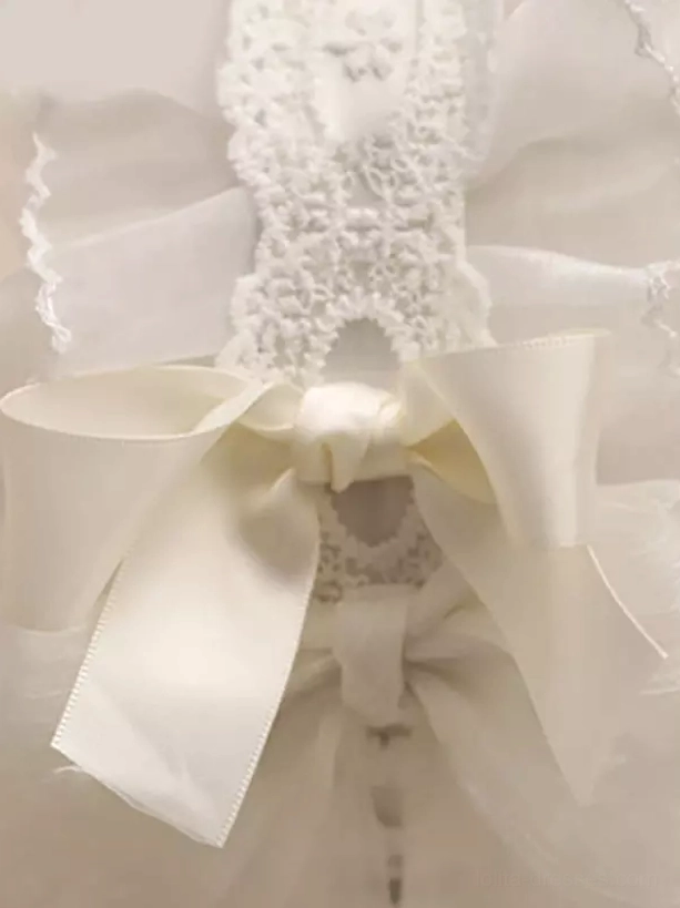 Close-up flat lay detail of lolita headpiece showing double satin bows, crocheted lace inlays, off-white sheer tulle fabric and ruffled trim embellishments highlighting fine craftsmanship of this classic lolita hair accessory
