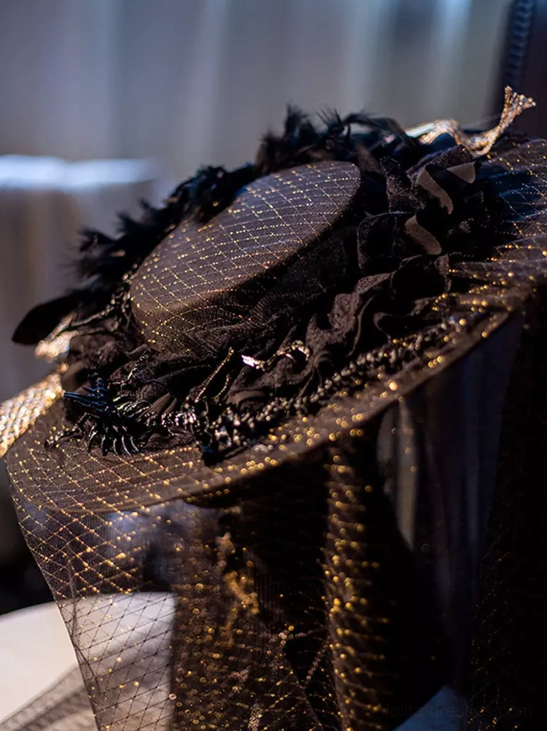 Front-facing detail of gothic lolita headdress showing ruffled black frill on hat brim, glitter mesh veil construction, and delicate feather accent embellishments