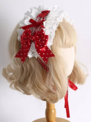 Sweet Lolita headdress with white eyelet lace and red polka-dot satin bow, right three-quarter view on blonde curly wig mannequin, featuring cream adjustable tie strap
