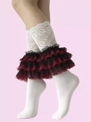 White floral lace ruffle calf socks with burgundy-black layered ruffles worn on human leg against pink background showing side front lolita aesthetic detail