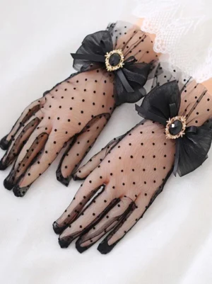 Black polka dot lolita sheer mesh gloves with black bow gem ornament close-up detail view
