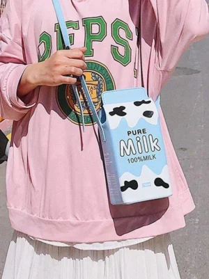 light-sky-blue-milk-carton-lolita-crossbody-bag-with-cow-spot-pattern-worn-by-model-in-pink-graphic-sweatshirt-outdoor-street-style