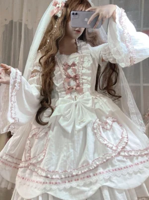 Sweet lolita one piece dress side profile view showcasing lace-trimmed bell sleeves, front pink bows, and large waist bow decoration on white base
