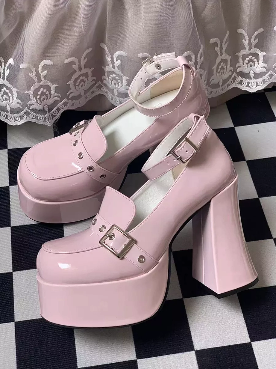Lolita style patent leather platform boots in black and white with thick platform soles and decorative metal buckle straps for tea party and themed events