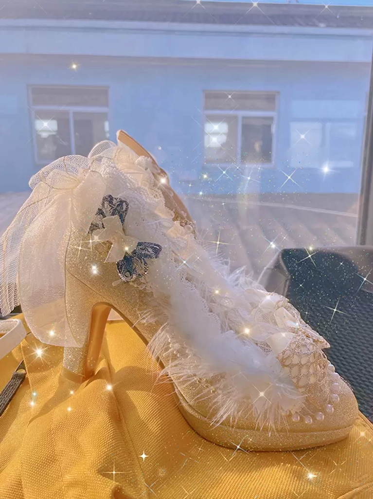 Close-up side view of single champagne lolita pump showing glitter upper, tulle bow, blue accent bow, and feather trim on round toe