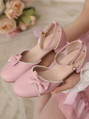 Elegant lolita ankle strap pumps pink held in hand with floral bouquet pearl edge trim bow decoration charm pendant