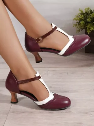Front-side on-foot perspective of T-strap Lolita heeled pumps featuring wine red upper with off-white toe trim and wooden grain heel detail