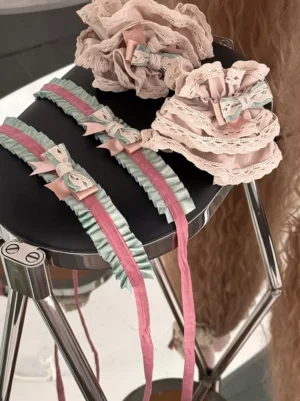 Lolita choker necklaces and ruffled flower ornaments featuring two-tone ribbons and lace accents, styled on vintage metal chair