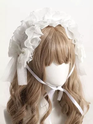 Delicate lolita ruffled lace headdress with organza bow and adjustable chin tie straps, featuring white embroidered lace panels and sheer tulle trim, worn on mannequin with light brown curly wig, front view showcasing classic lolita headwear design