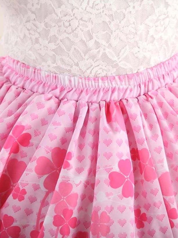Close-up detail of pink lolita skirt waist and fabric showing elastic gathered waistband, clover pattern print with micro heart grid base, and embroidered details