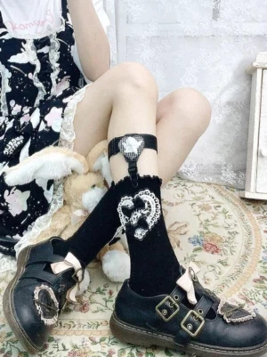Side view of adjustable lolita stocking garter with heart lace bow ornament worn on seated legs against vintage floral pattern carpet