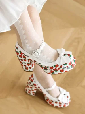 Lolita white strawberry print chunky pumps with decorative front bow and pearl ankle buckle, worn with sheer dotted socks, top side view