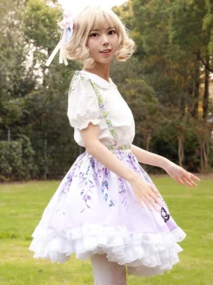 Green suspender straps and three-quarter side view of lilac lolita skirt showing ruffled underskirt construction and a-line silhouette on model in outdoor setting