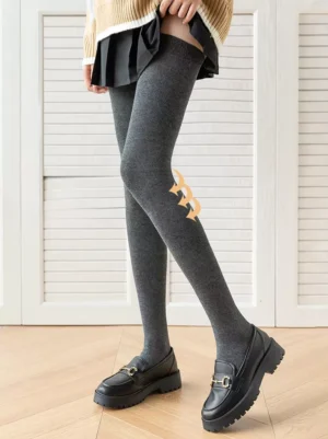 Dark gray lolita knee-high socks styled with pleated skirt leather loafers and golden bow decoration front view