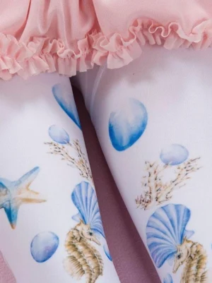 Close-up detail of blue seahorse starfish and shell prints on sweet lolita pantyhose worn with pink ruffled skirt