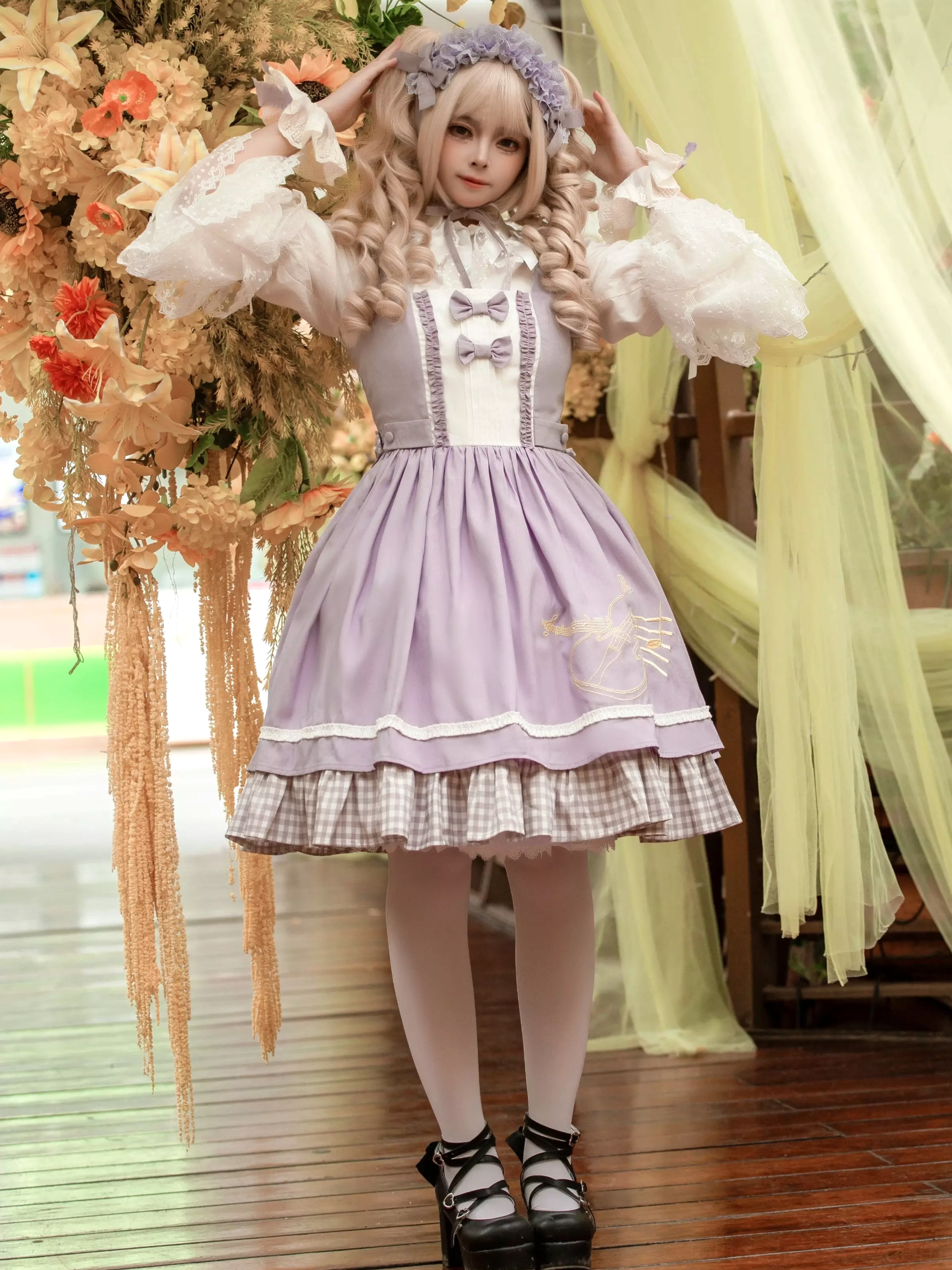 Lolita dress low angle front view showing lace puff sleeves gingham skirt trim and decorative wrist bows details