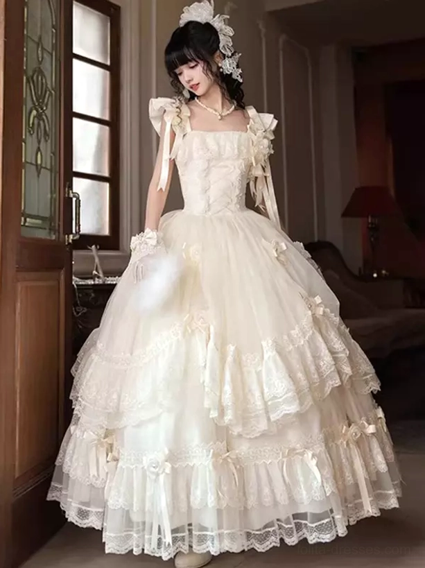 Elegant fairy tale Lolita wedding dress featuring fitted corset bodice and voluminous tiered tulle skirt, front standing pose with floral hair ornament in vintage indoor setting