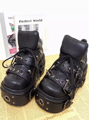 Gothic Lolita boots featuring lace-up closure and thick studded platform sole displayed on newspaper background with decorative books styling