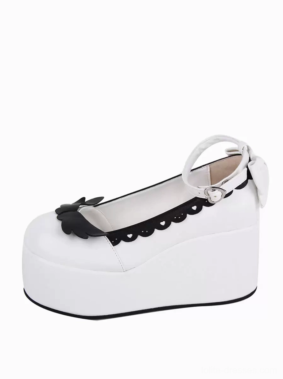 Single Lolita wedge pump side close-up view showing thick platform sole scalloped collar black butterfly decoration ankle strap buckle and bow