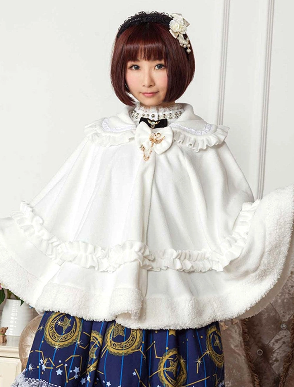 white lolita cape with bow brooch and ruffled waist trim side angle view indoor vintage setting