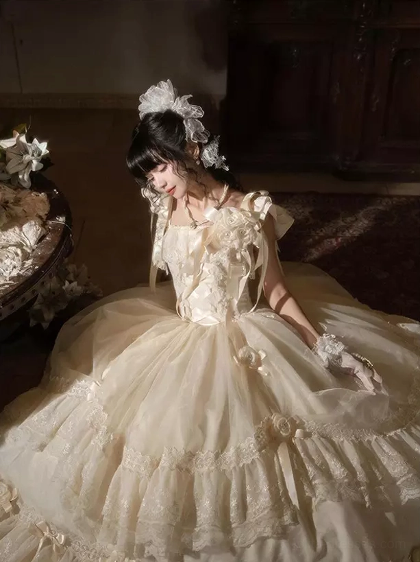 Romantic white Lolita dress side profile showcasing soft tulle ballgown silhouette with bow and lace hem details, female model against vintage floral sofa backdrop