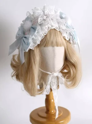 Lolita headdress side view showing layered ruffled lace trim, chin strap details, and light blue decorative accents on wooden display stand