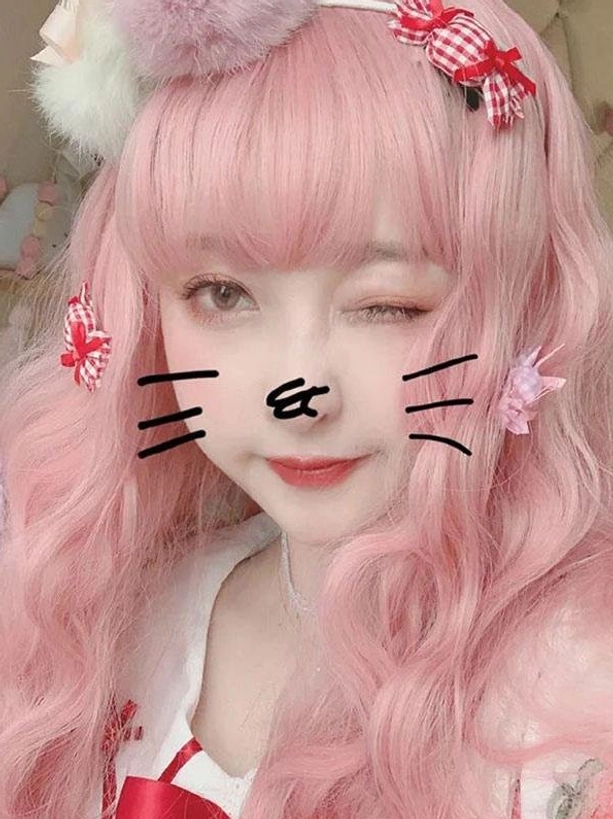 Close-up face view of sweet lolita wig in light pink with cute cat face doodle and red bow collar detail winking expression