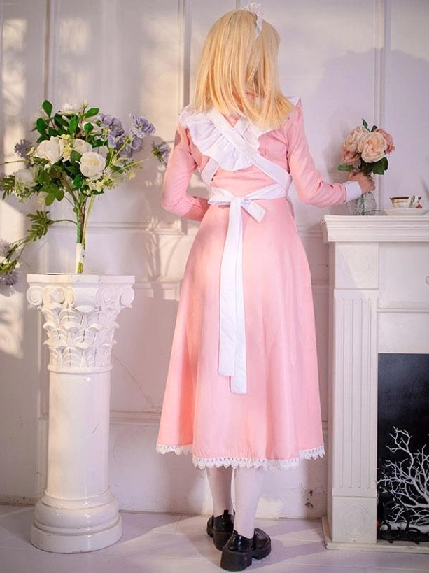 Maid lolita dress back view showing white waist sash and ruffled back trim with vintage fireplace setting