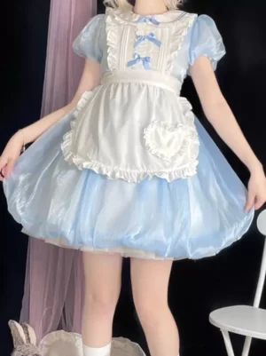 Maid-style Alice lolita one-piece dress featuring ruffled heart-shaped apron, puffed shiny blue bubble skirt with bow decorations, front side full-body view with white knee-high socks and white chair styling