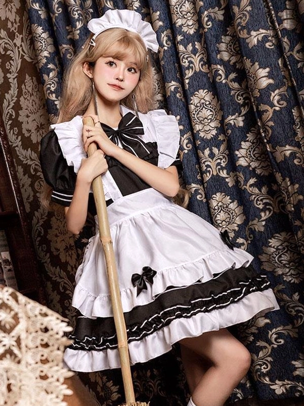 Black maid lolita dress side front view showing layered ruffled skirt with striped trim and short ruffled sleeves on model