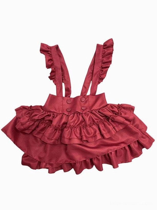 Red ruffled pinafore skirt flat lay showing multi-layered ruffle hem, buttoned waistband, ruffled shoulder straps, and two-piece construction detail