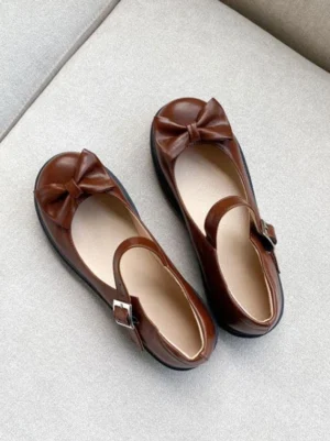 Brown Mary Jane Lolita flat pumps with bow toe detail and metal ankle strap buckle - flat lay top view