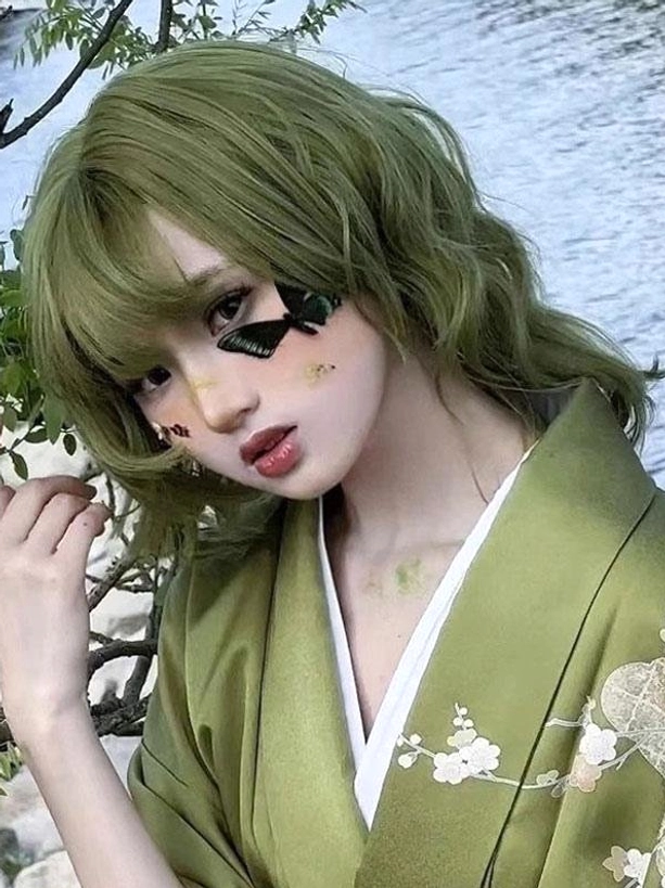 Matcha green heat-resistant lolita wig close-up three-quarter front view showing wavy hair texture and makeup detail with matching kimono