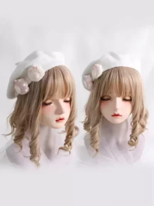 Pair of matching white fuzzy Lolita berets with cat paw ornaments displayed on two doll mannequins front facing view