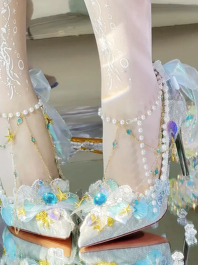 Symmetrical mermaid Lolita pumps both feet top down view ocean embellishments pearl shoe edges mirror reflective tabletop photography