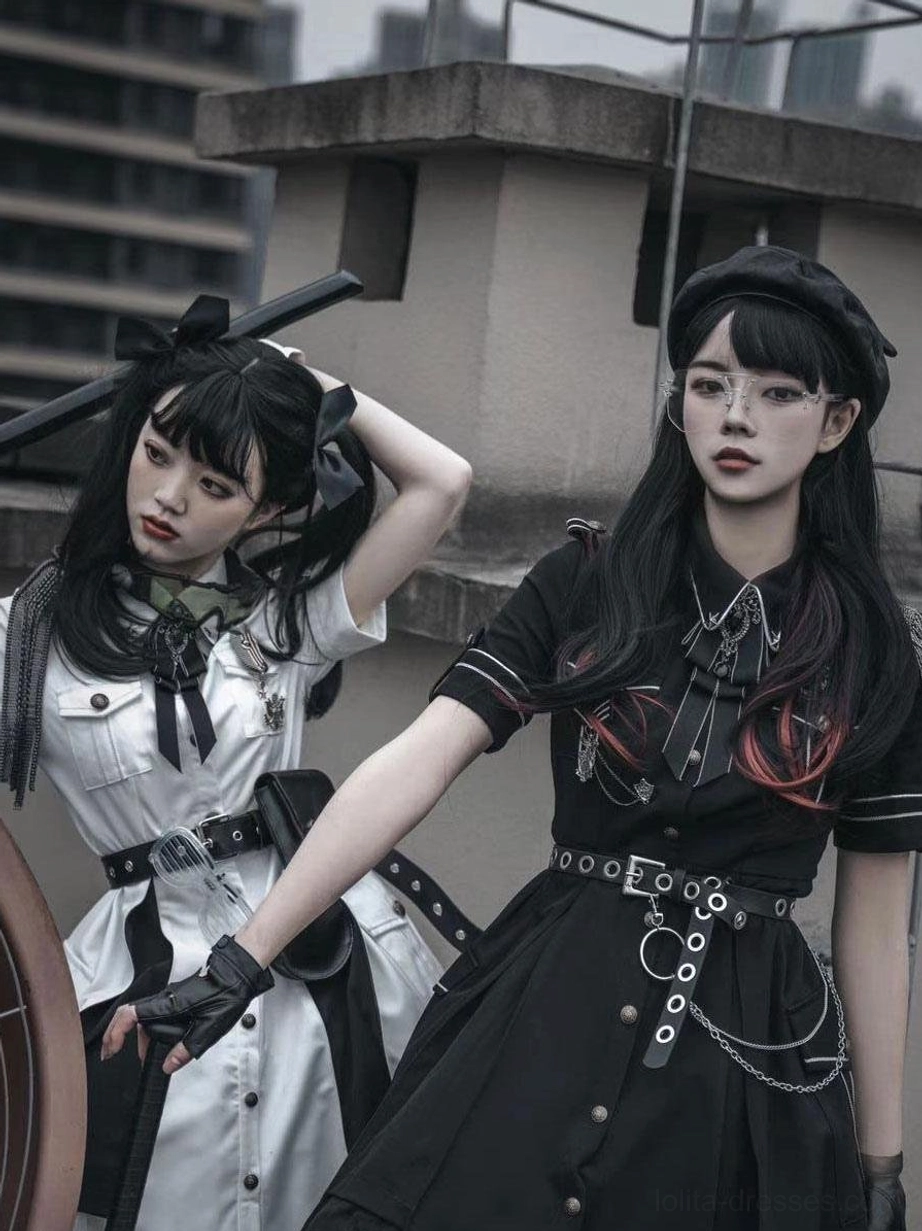Two female models outdoor rooftop wearing military Lolita dress sets black and white with berets fingerless gloves and detailed waist chains