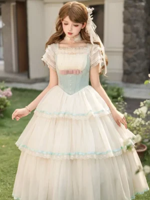 Mint green and cream fairy lolita JSK corset dress with tiered tulle skirt, front full-body view on model in outdoor garden setting