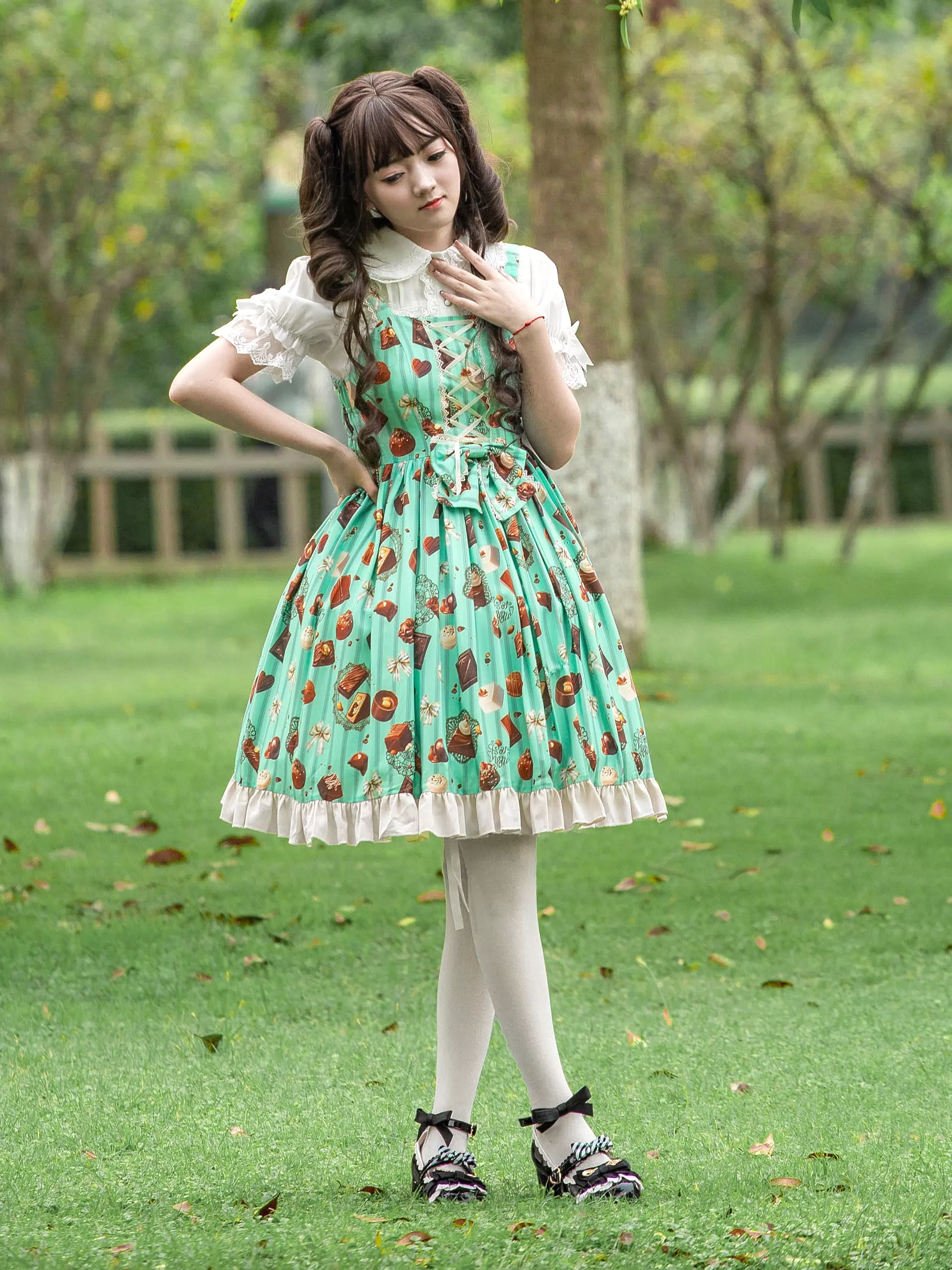 Mint green sweet Lolita JSK dress three-quarter front angle showing waist bow embellishment and ruffled silhouette outdoor garden