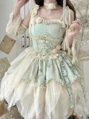 Mint green fairy lolita dress with lace-up corset bodice and layered tulle skirt, worn by female model holding decorative oiled paper umbrella, showing full front three-quarter view with dimensional 3D flowers and ruffled trims