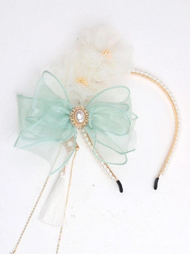 Mint green Rococo Lolita headdress with pearl gem center gold headband trim white flowers side view flat lay detail