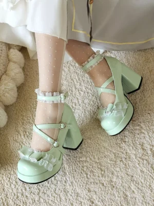 Mint green Lolita platform pumps top-down on-foot view featuring double cross buckle straps, ruffled ankle band and front bow detail with soft carpet backdrop