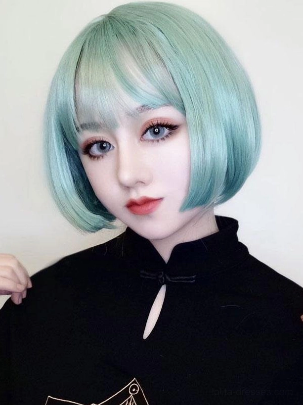 Mint green short bob lolita wig sweet style with blunt bangs glossy texture close-up on model in solid black top indoor studio