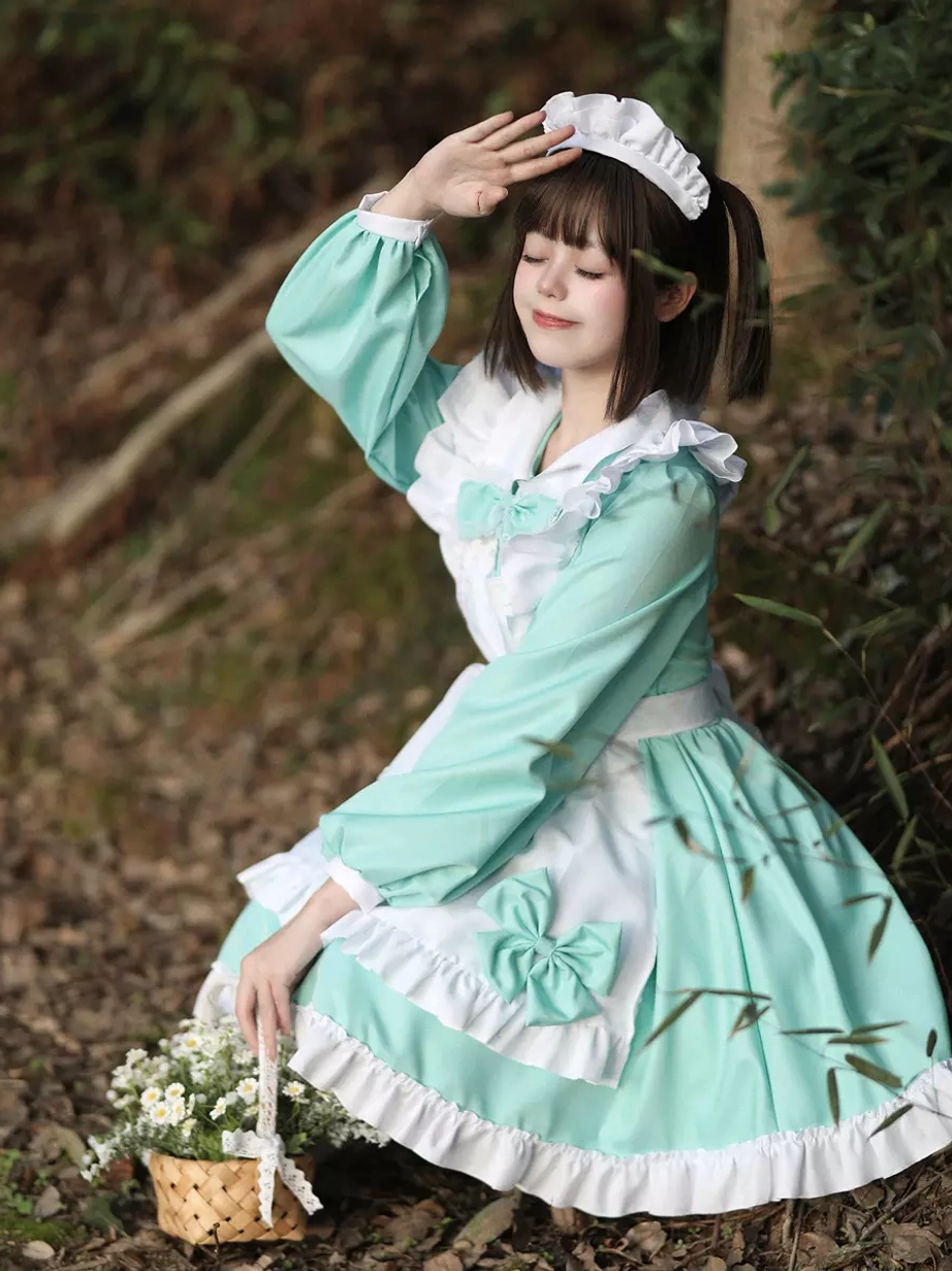 Mint green maid lolita dress side-front view on model with flower basket prop outdoor woodland setting