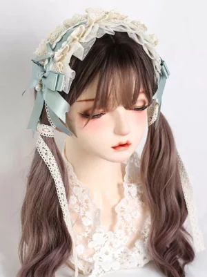 Mint green satin bow Rococo lace Lolita headdress with cream ruffled lace and pearl charm, displayed on mannequin with twin tails, frontal headshot view