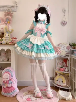 Full-body front standing view of mint green maid-style sweet lolita dress with white ruffled apron, off-shoulder ruffled cuffs, tiered skirt layers, paired with white thigh-high socks and pink loafers