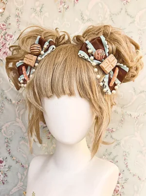 Mint green twin bow lolita headdress with pearl trims and dessert charms displayed on mannequin with twin curly buns wig, vintage floral backdrop, front view